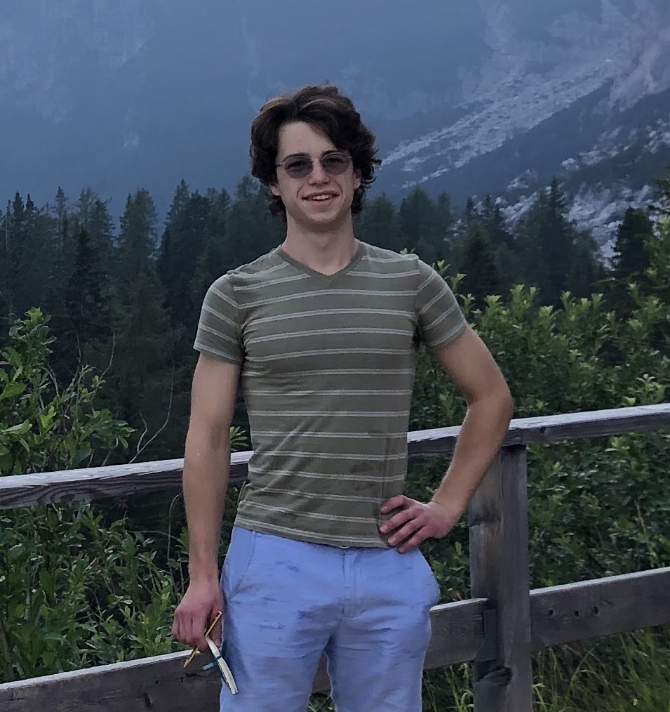 A person standing in front of a mountain

Description automatically generated